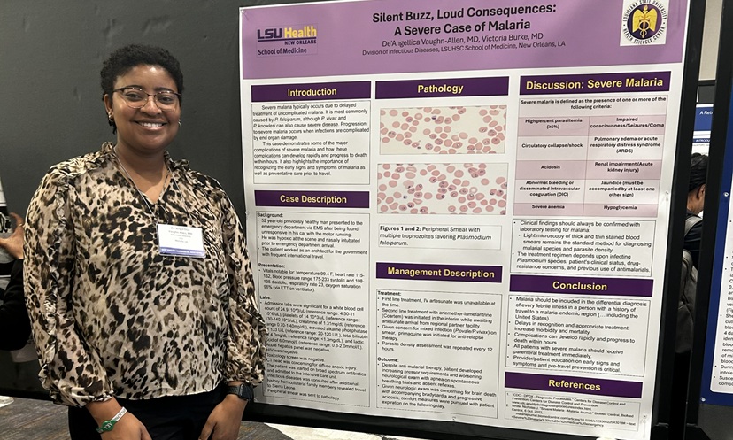 Conference attendee poses next to an LSU Health research poster presenting a severe malaria case study at a professional academic meeting.