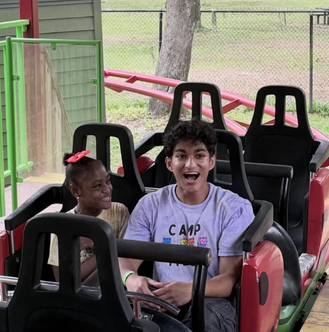 small child expresses delight on ride with camp counselor
