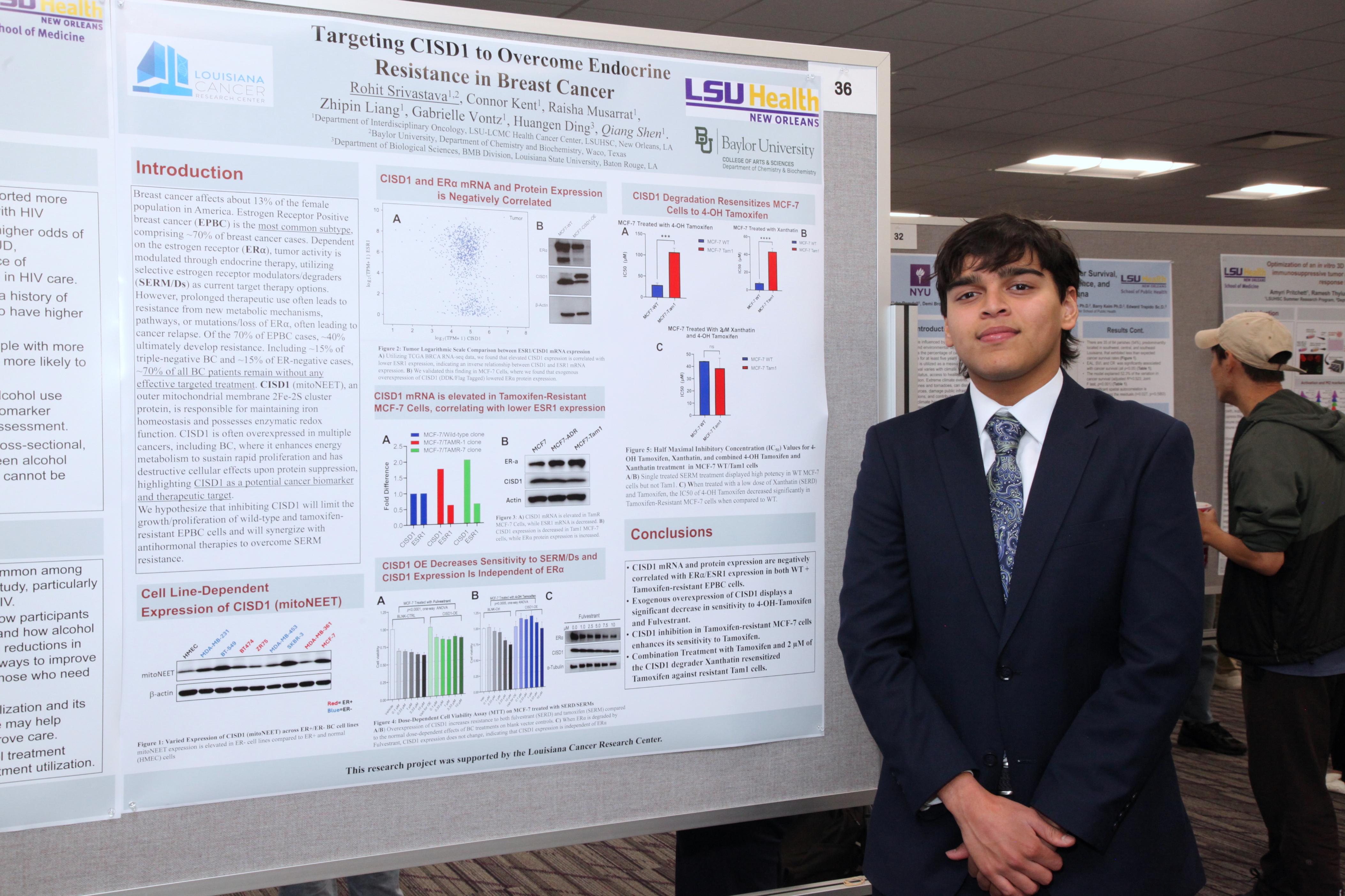 intern stands by his research poster