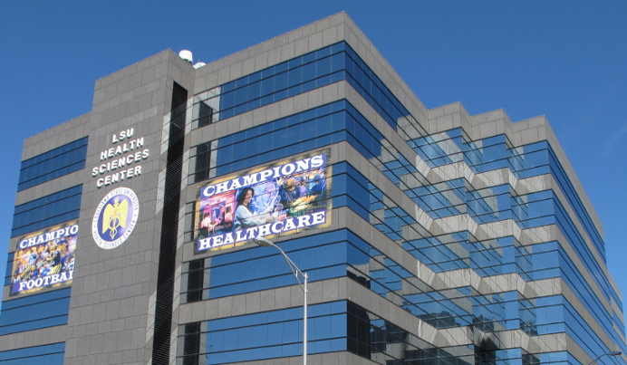 Photograph of the LSU Health Sciences Center building with reflective glass windows.