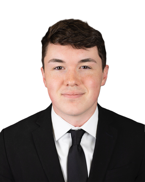 Professional headshot showing a person wearing a black suit jacket, white dress shirt, and black tie. The subject is facing the camera against a plain black background. The image is tightly cropped around the head and shoulders with even lighting and no visible text or logos.