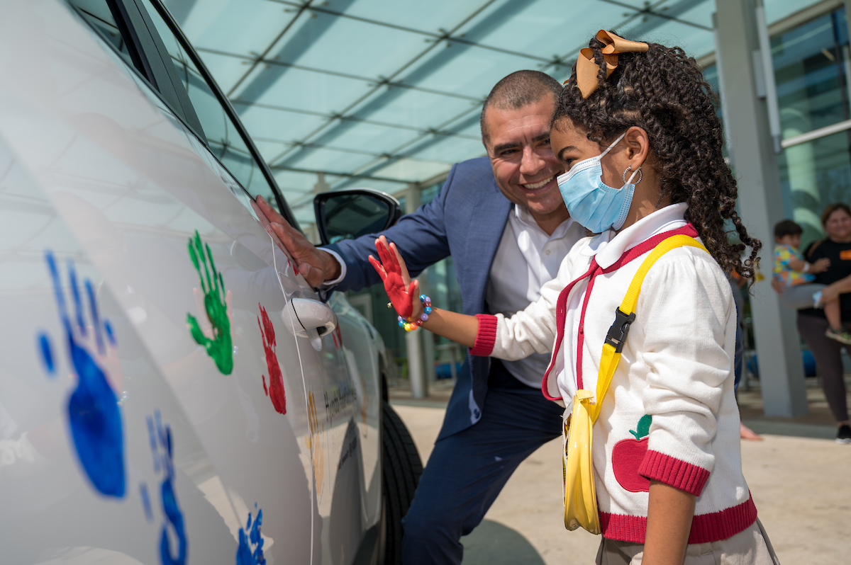 child puts handprint on car