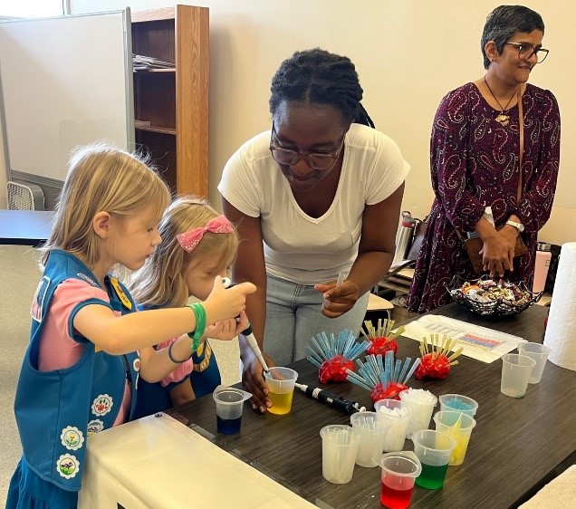 Wema Kibanga demonstrates how to pipette to young girl