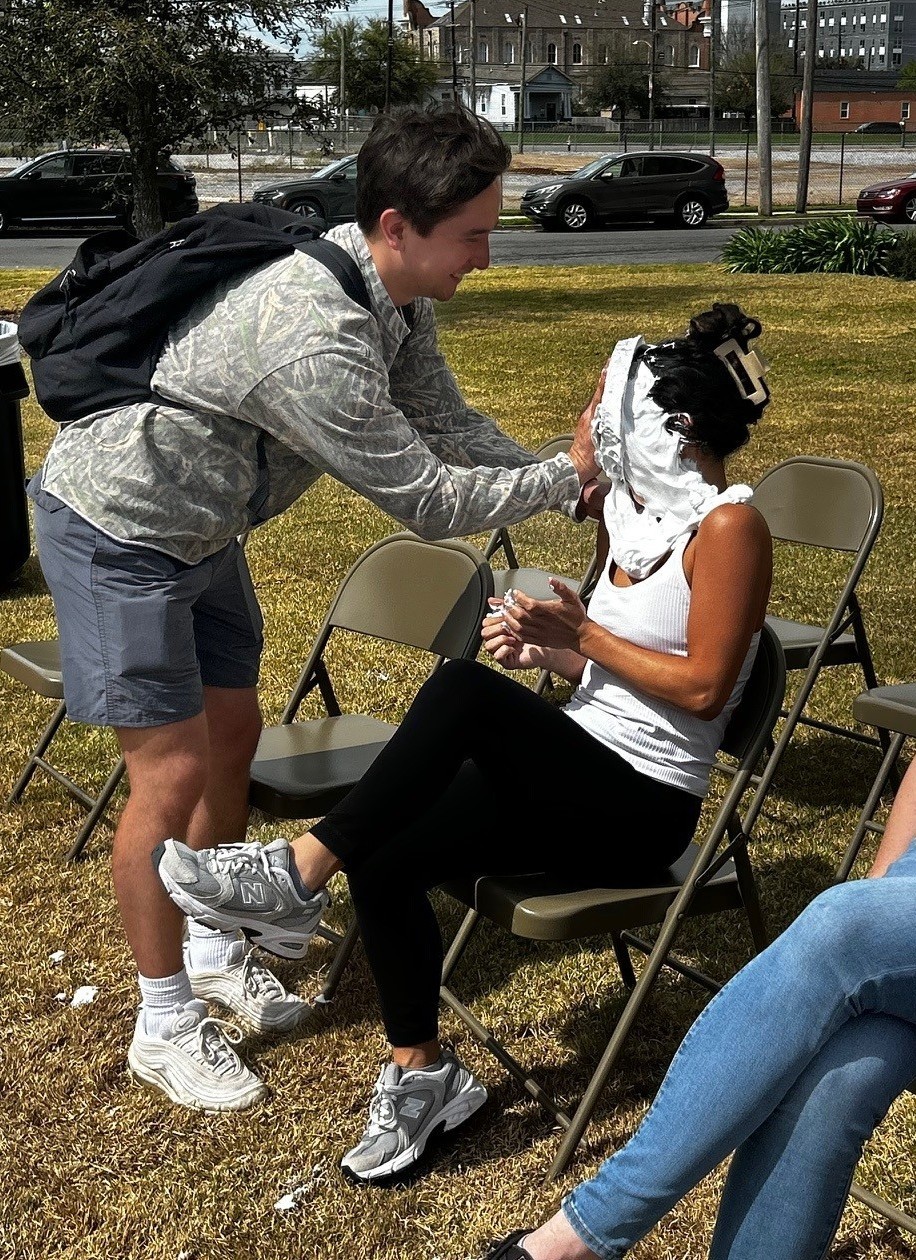A volunteer gets pie in her face.
